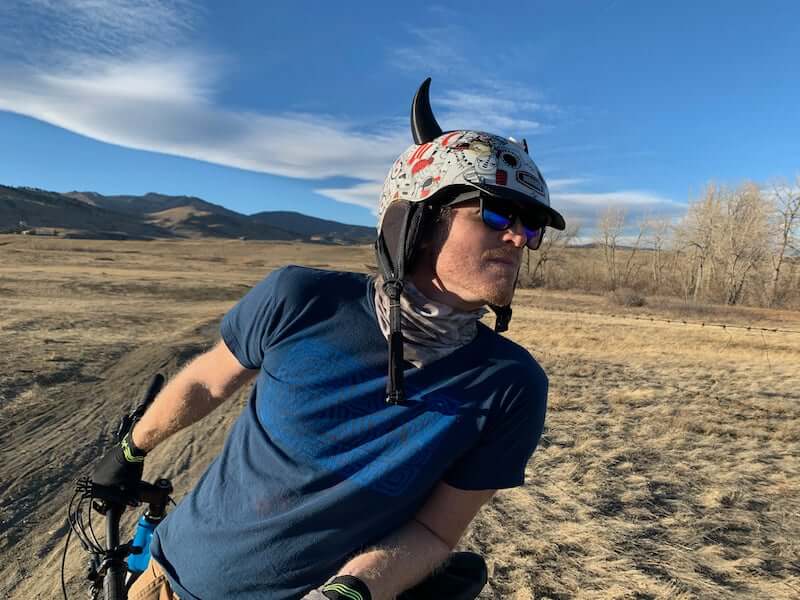 Black devil horns on a bike helmet blue sky background