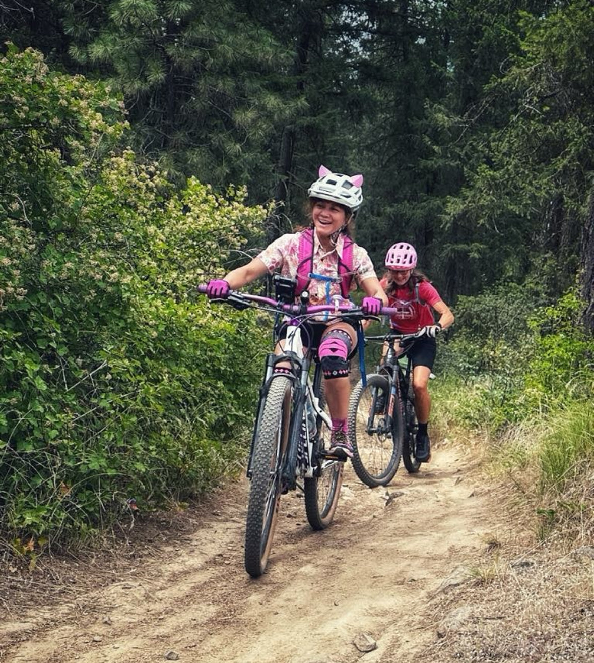 Woman mountain biking while wearing a helmet with pink kitty ear Helmet Flair accessories