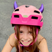 Girl wearing small purple horns on her bicycle helmet