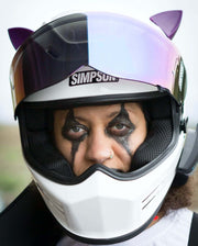 Purple cat ears on a motorcycle helmet with cool halloween makeup on a woman's face