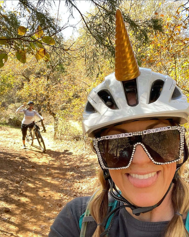 Woman wearing a gold unicorn horn on her bike helmet