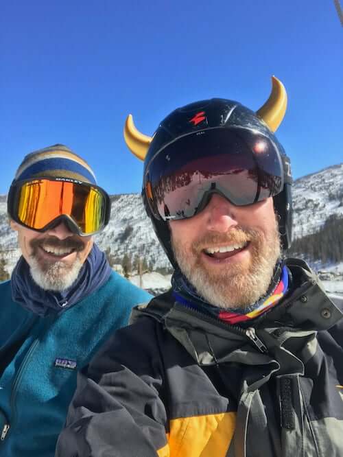 Gold devil horns on a ski helmet with blue sky background