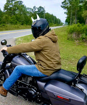 Large white horns on a motorcycle helmet worn by a man on a black motorcycle